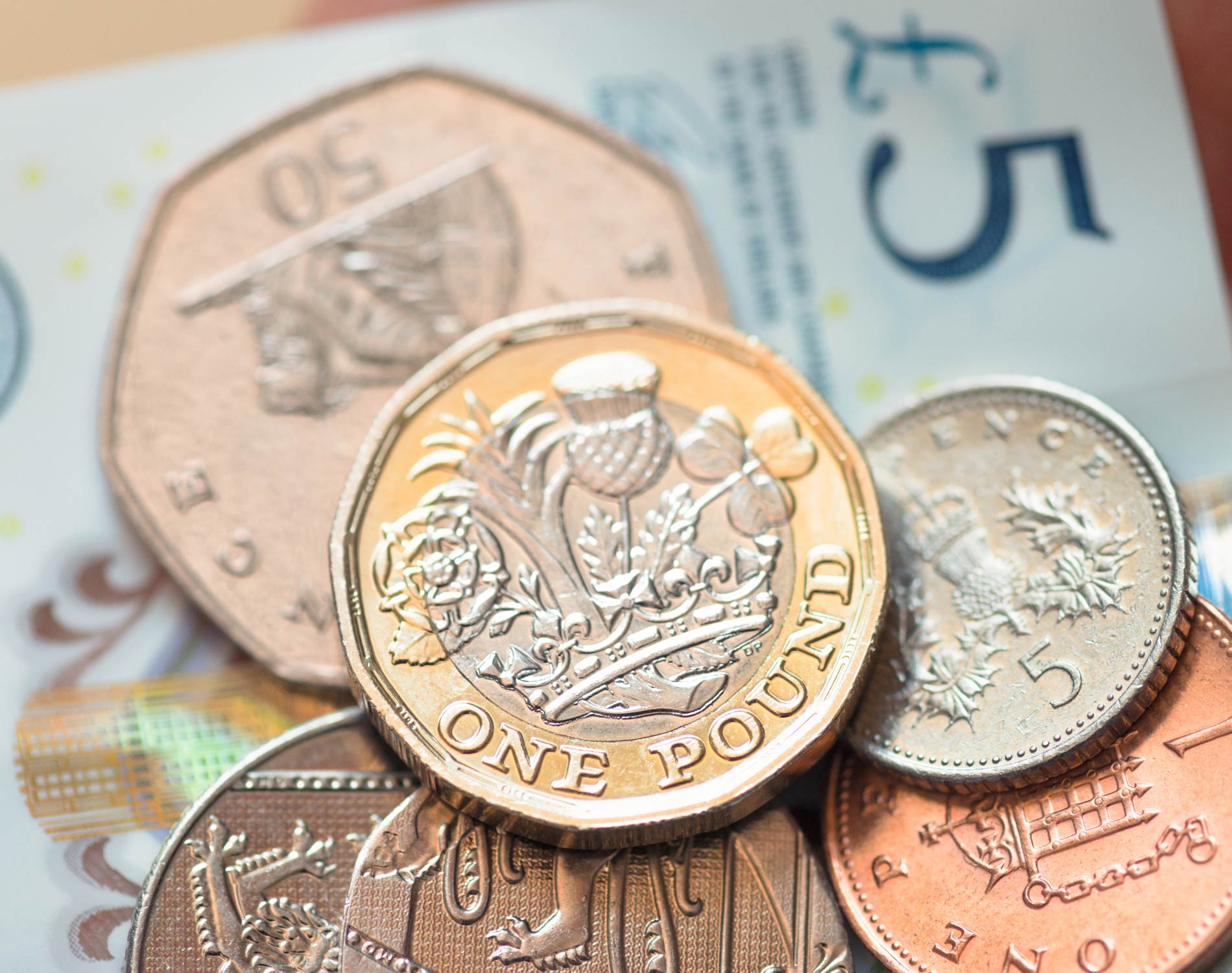 British five pound note and coins