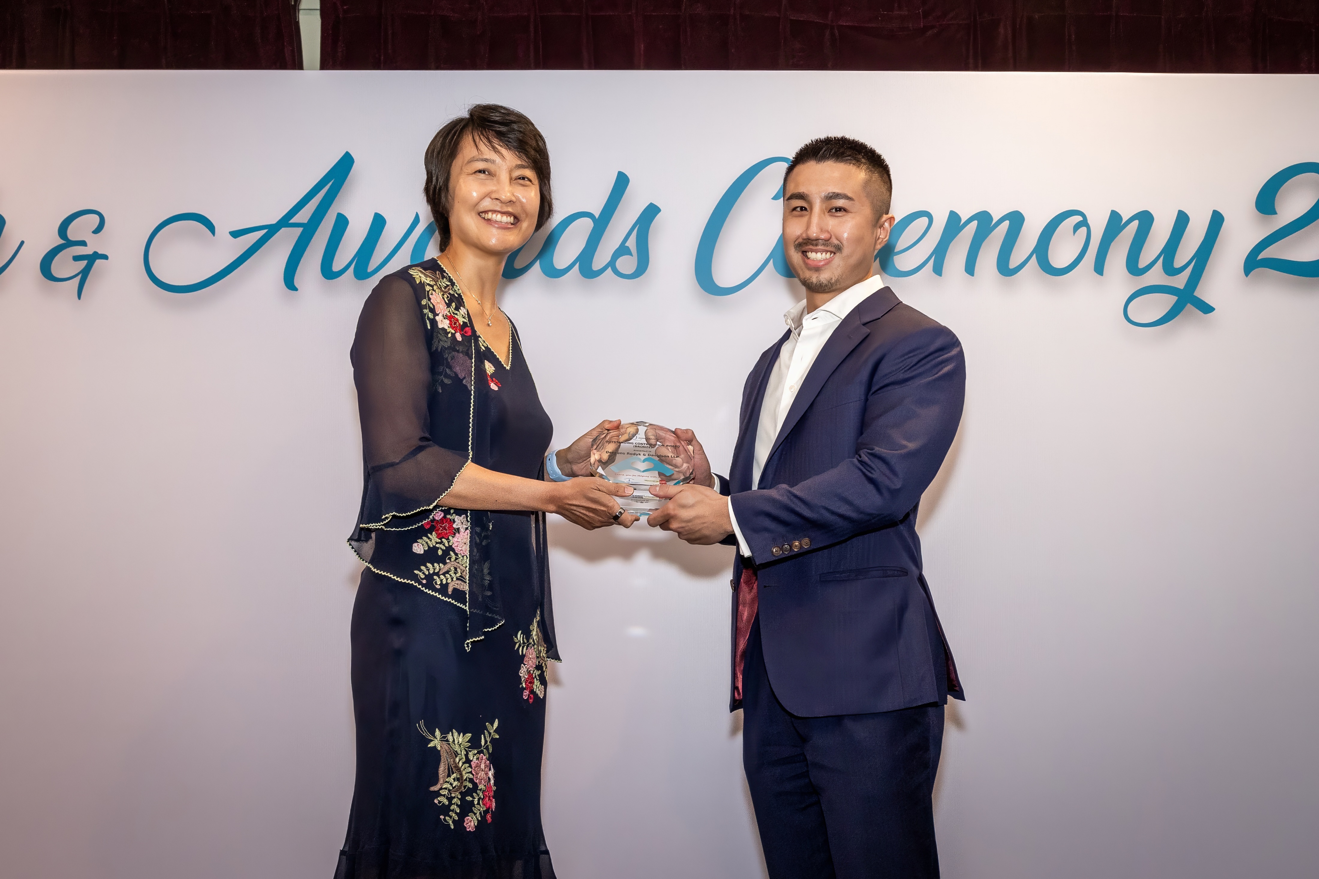 Senior Associate Alwyn Tan received the award on behalf of the firm from Ms. Lim Hui Min, the Director of Legal Aid